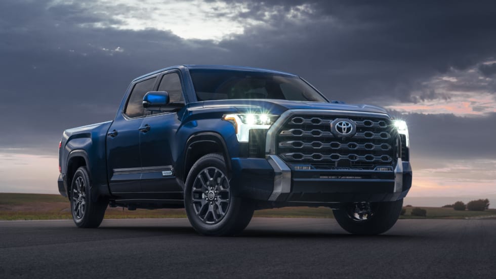 A blue 2022 Toyota Tundra is shown with its headlights on.