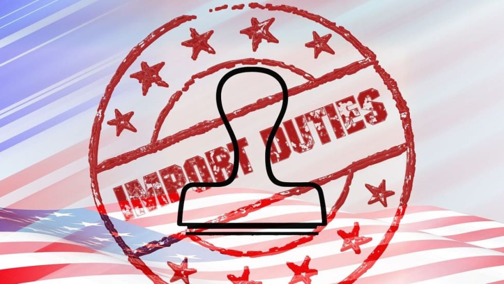 An import duties stamp and stamper superimposed on a flat American flag.