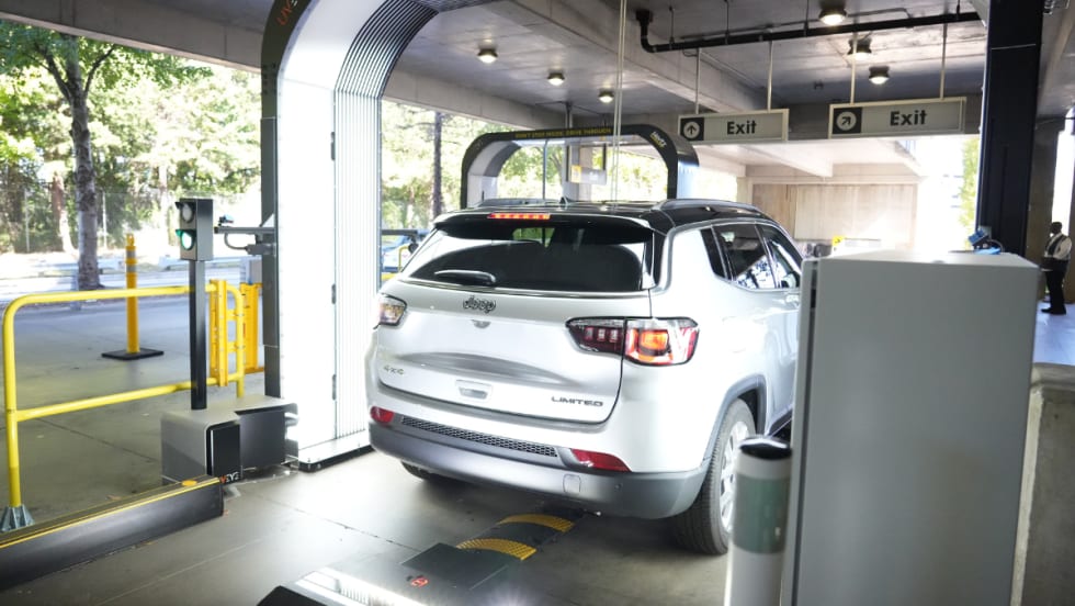 A rental car rolling through a UVeye overhead vehicle inspection terminal.