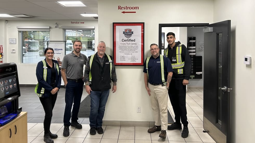 Five people stand together in an office