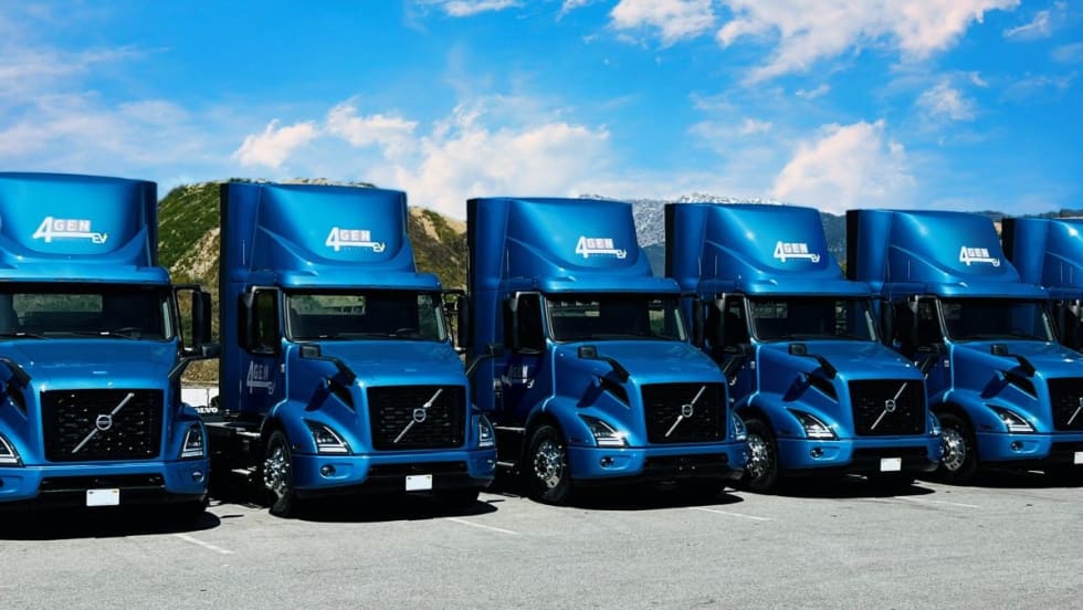 Several blue Volvo VNR Electric Trucks.