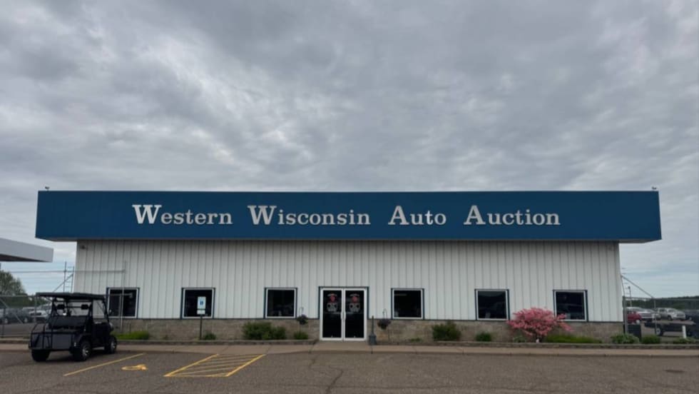 The front of the main building at Western Wisconsin Auto Auction on a cloudy day.