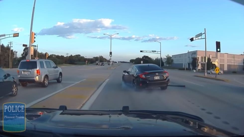 Police dashcam view of intersection with traffic and vehicles