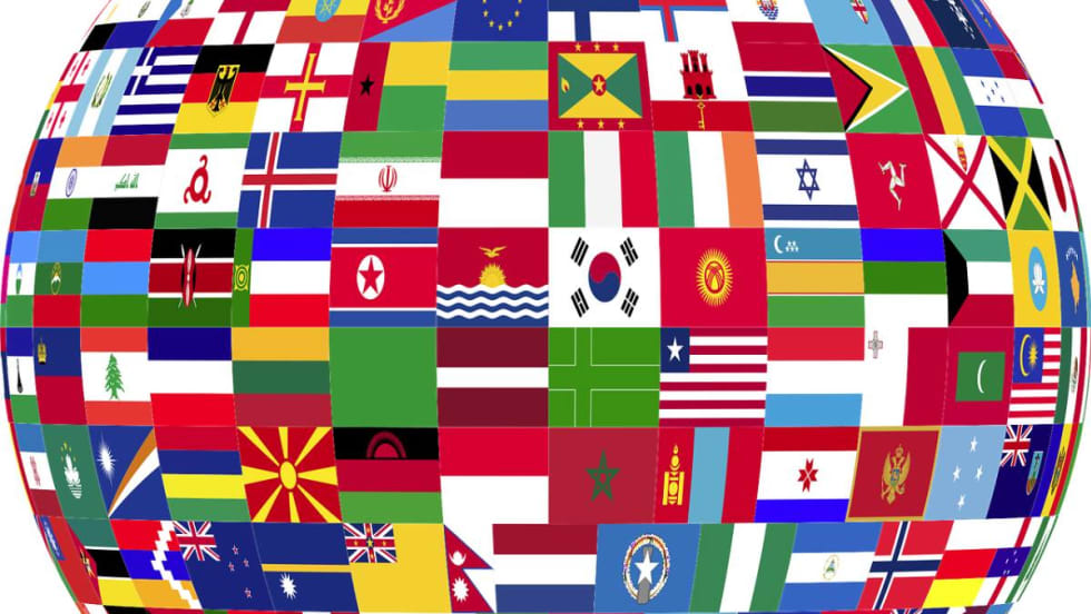 Close-up of the mid-section of a globe covered in flags of the nations.