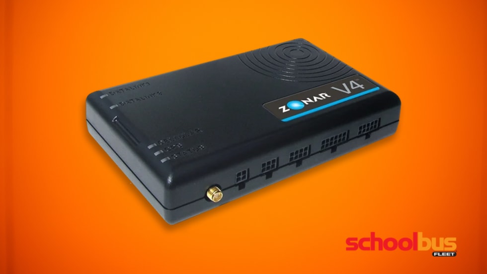 Black Zonar V4 telematics device shown on an orange background, a rectangular fleet telematics unit with status indicator lights and connection ports used in commercial vehicles to collect operational and emissions data.