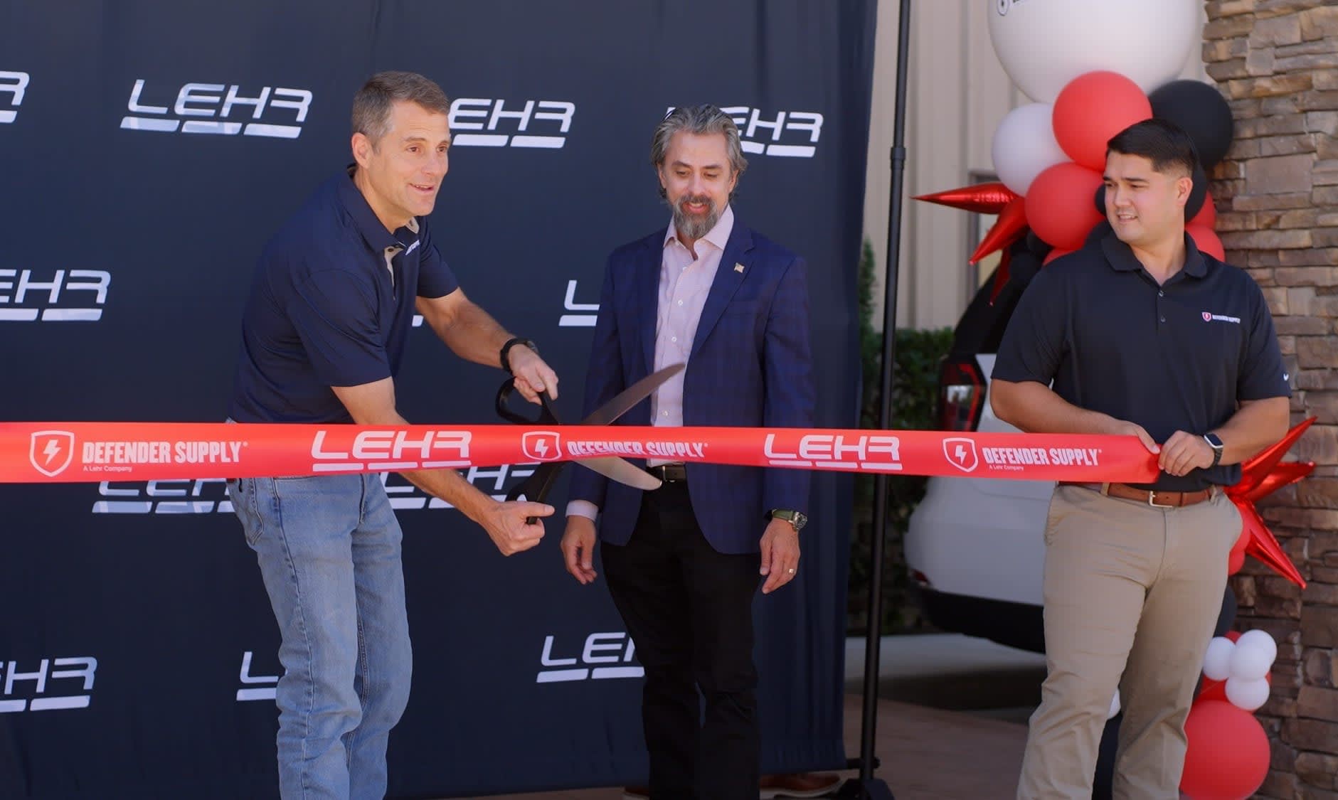 Three mean cut a ribbon.