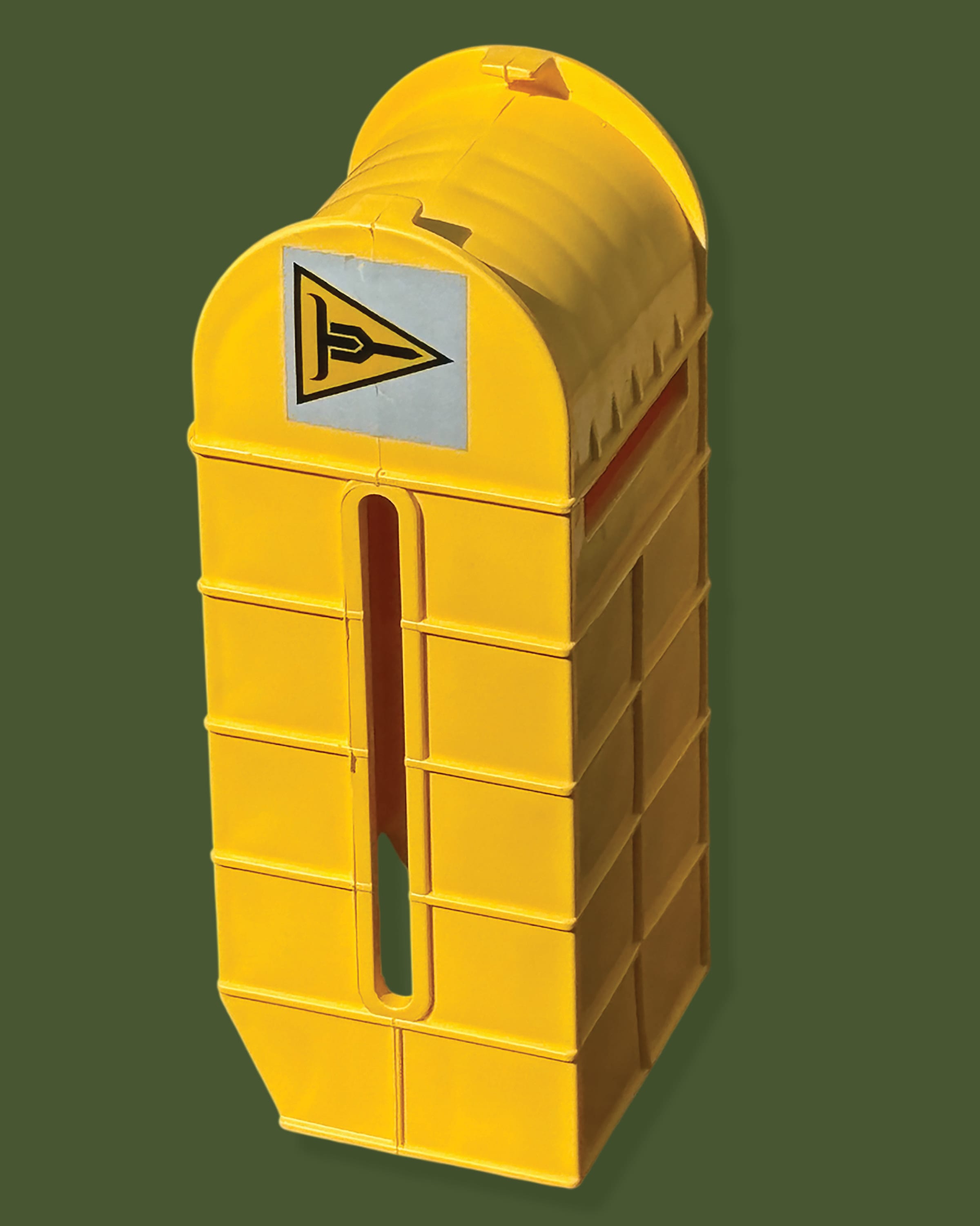 Image is a single, yellow TruckersYoke Brand Strapping Block standing upright on a green background. Product is yellow and has the white and yellow triangular logo placed on the flat end of the curve.