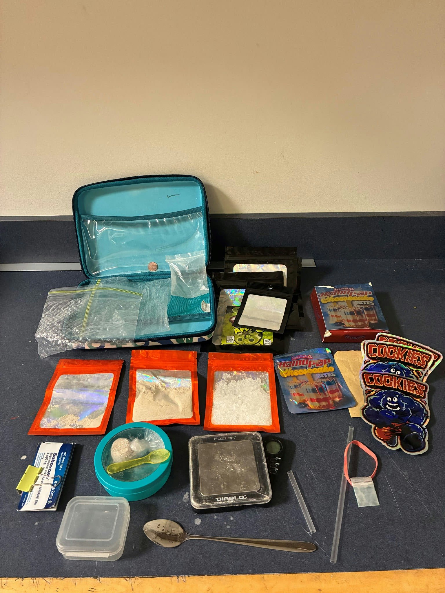 Assorted drug paraphernalia and related items spread out on a dark surface
