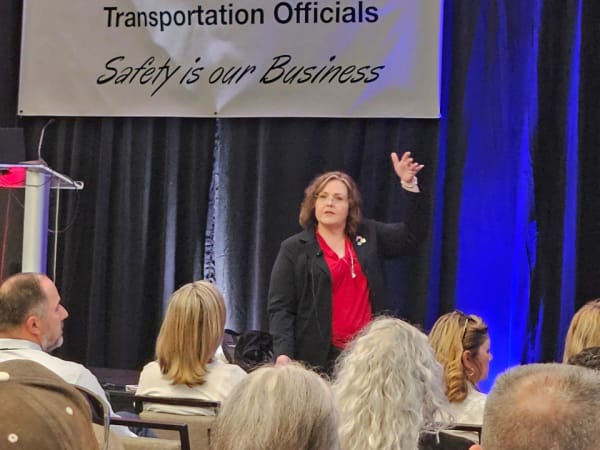 Kerri Gardner addresses attendees from the stage under a CASTO banner reading “Safety Is Our Business,” engaging the audience during a session.