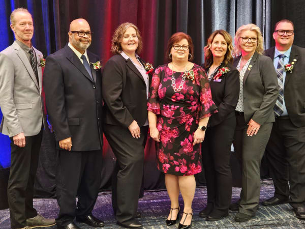 Members of the CASTO executive committee pose together on stage in formal attire following the business meeting and awards ceremony.
