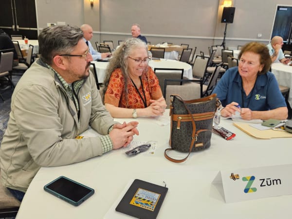 Attendees converse at a round table during a networking meet-and-greet session sponsored by Zum.