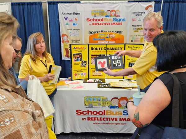 three attendees talk with a vendor during a trade show