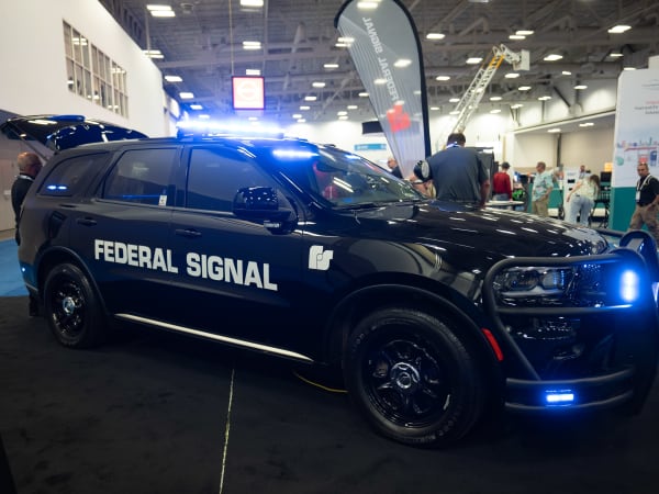 A black Dodge Durango Pursuit with a Federal Signal decal is shown with lights flashing.