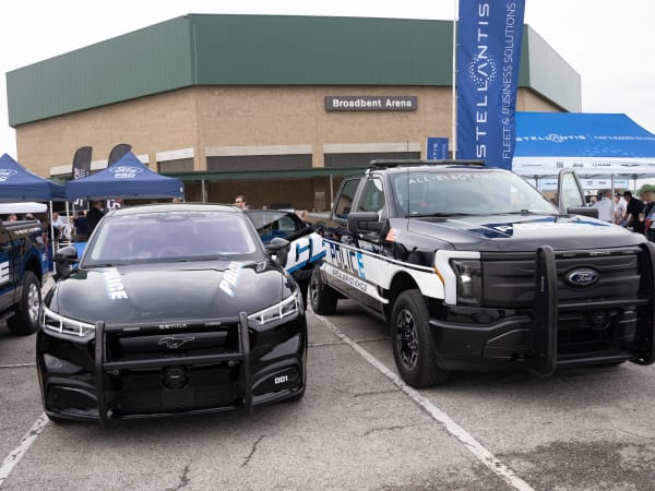 A black Ford Mustang Mach-E is shown next to a black Ford F-150 Lightning Pro SSV.