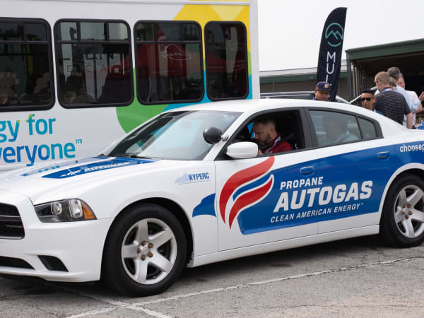 A Ford Champion transit bus and Dodge Charger pursuit sit side-by-side in the Ride & Drive lineup.