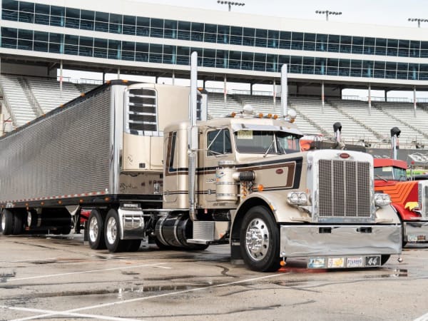 A beige Peterbilt Model 389 with trailer.