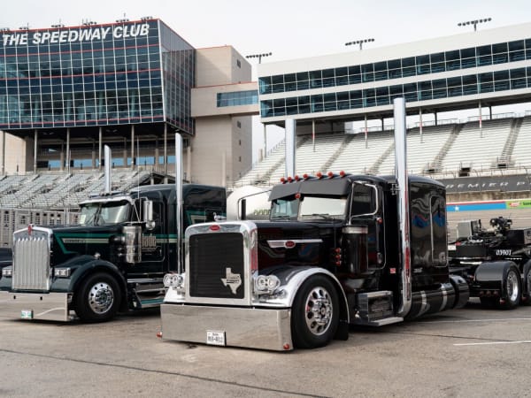 Kenworth and Peterbilt long-nose conventional trucks on display at the Texas Motor Speedway.