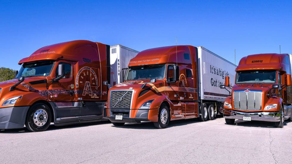 Three Arka Express tractor-trailers, Freightliner, Volvo, and Peterbilt