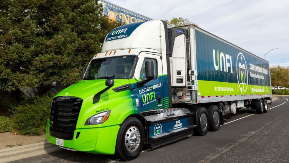 Green UNFI tractor-trailer with refrigeration unit (TRU)