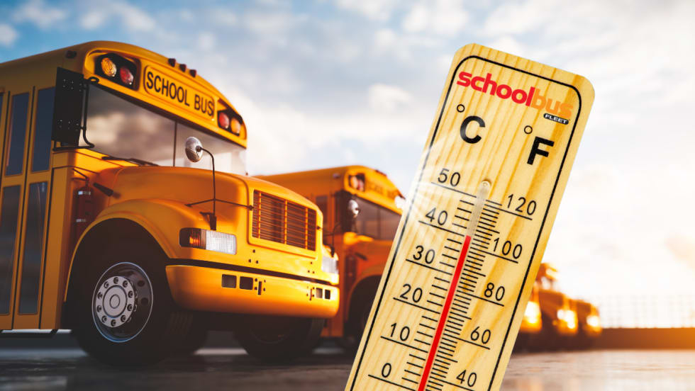 School buses in the sun with a thermometer in front.