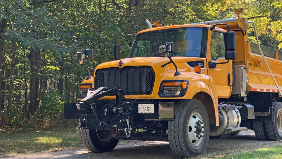 Yellow International HV truck on gravel road in the woods