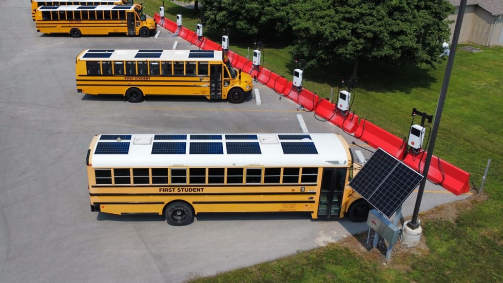 school buses with solar panels at charging stations