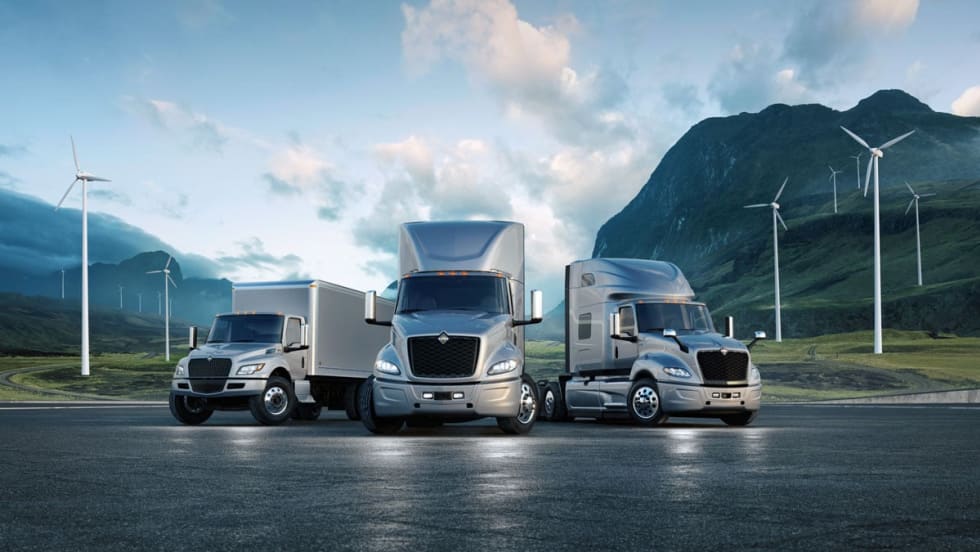 Navistar International electric trucks with wind turbines in background