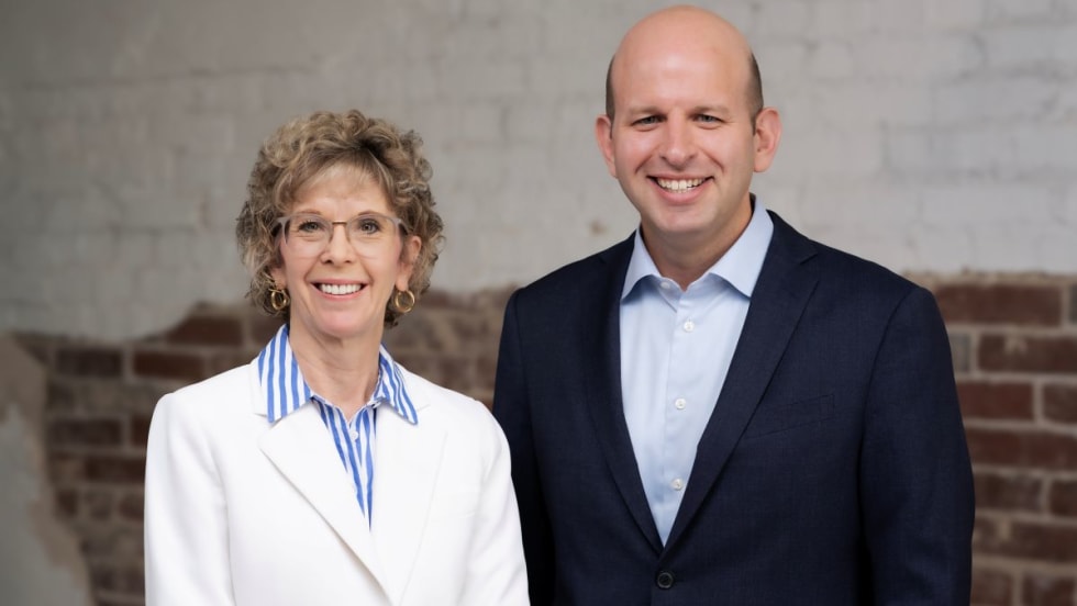 ArcBest's Judy McReynolds in white blazer next to Seth Runser in blue blazer.