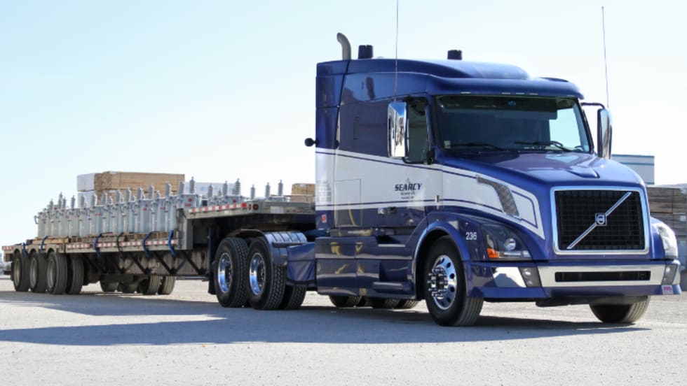 Photo of a Searcy truck pulling an open deck trailer