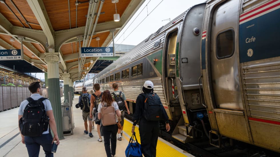 Passengers board an Amtrak train at Washington Union Station’s new Track 22 platform under a covered structure with clear signage and updated accessibility features.