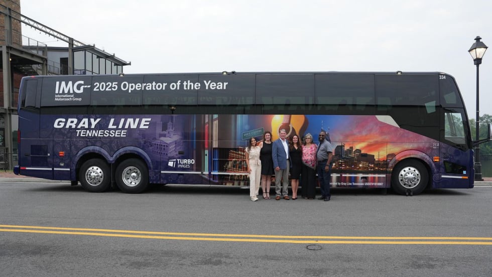 Gray Line Tennessee team poses in front of a custom motorcoach wrap celebrating the company’s recognition as 2025 IMG Operator of the Year.