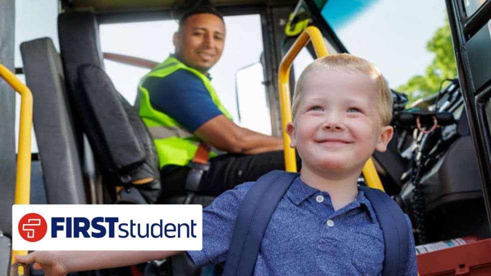 Young student boarding a school bus with driver in background, representing First Student’s new transportation partnership with Seneca Valley School District.
