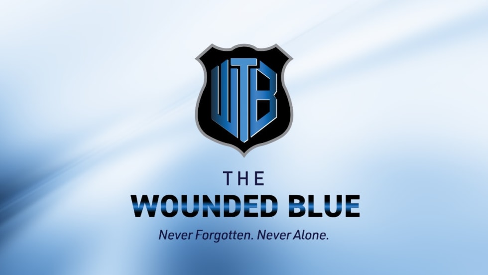 The Wounded Blue logo: shield emblem with WB letters in blue and black