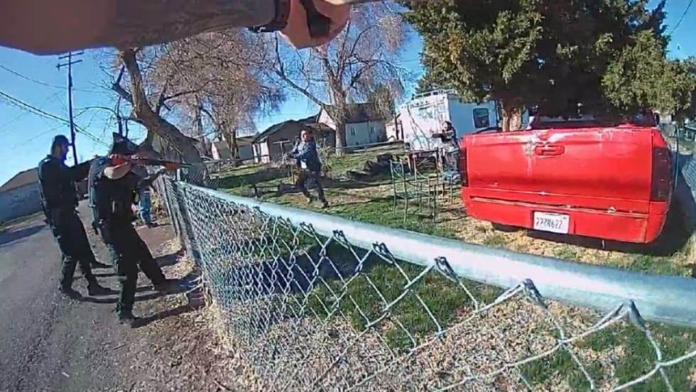 Law enforcement officers near chain-link fence with red truck in residential neighborhood