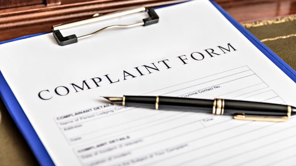 Complaint form on clipboard with black pen, ready for filing a formal written complaint