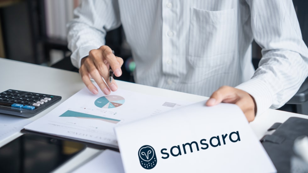 Close-up of a person reviewing charts and a document featuring the Samsara logo, representing research findings on disaster preparedness and operational resilience.