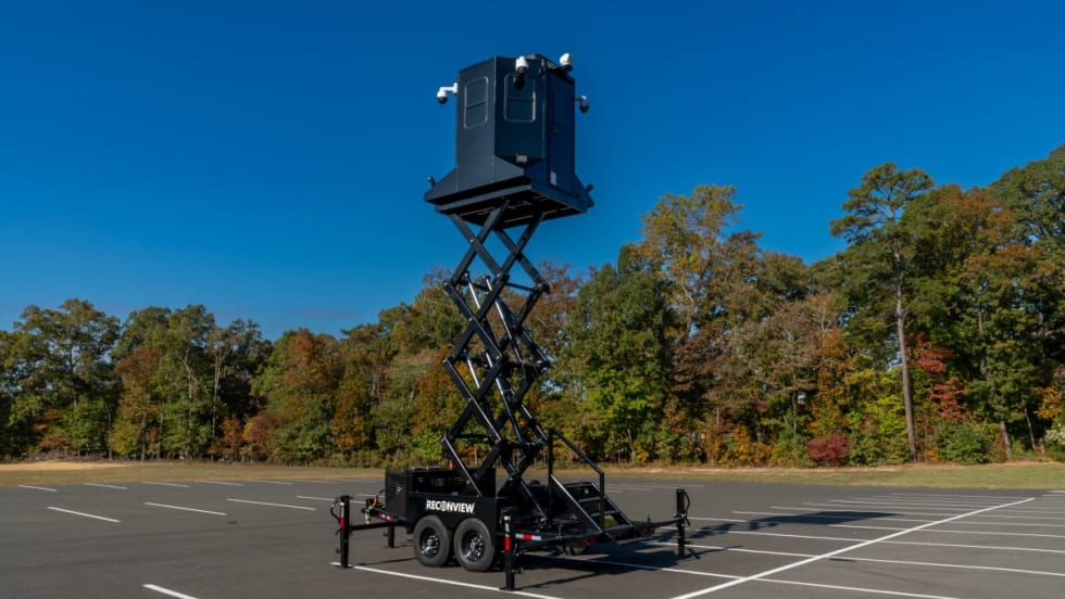 view of a mobile observation trailer deployed in a parking lot against a blue sky