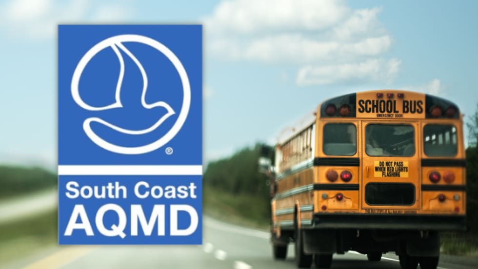 South Coast AQMD logo alongside a school bus driving on a roadway, representing new funding to replace diesel buses with zero-emission models for Southern California school districts.