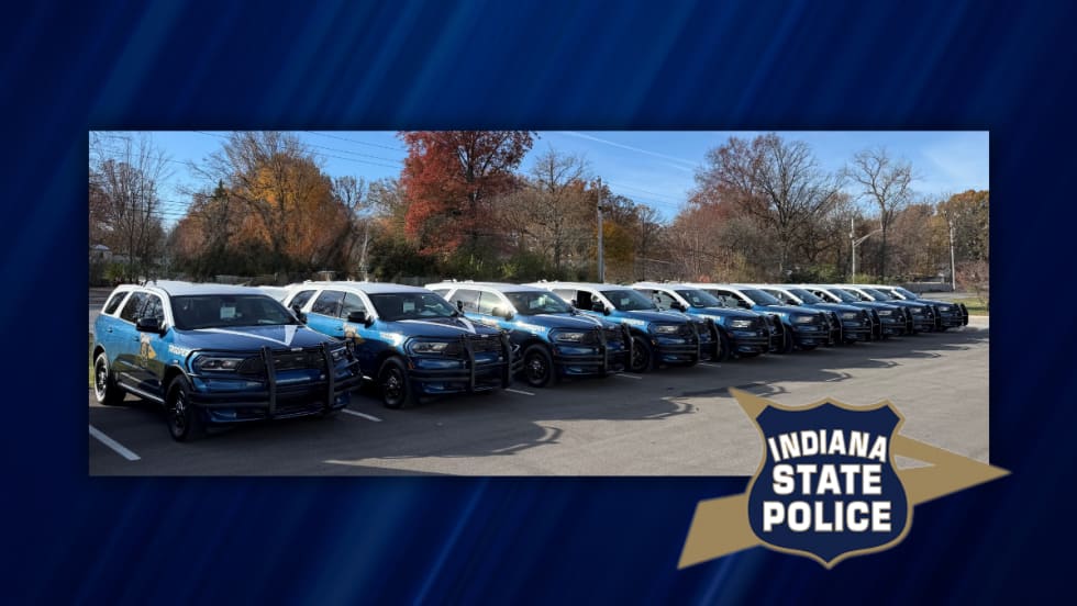 Row of newly designed Indiana State Police Dodge Durango patrol vehicles parked outdoors, marking the rollout of the new fleet design for graduating troopers.