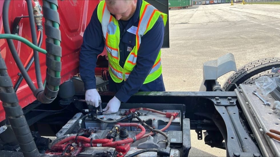 Truck technician installing Clarios' IdleLess battery monitoring system