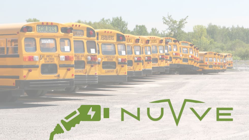 Row of yellow school buses parked in a lot with the Nuvve logo and an electric charging icon overlaid in the foreground.