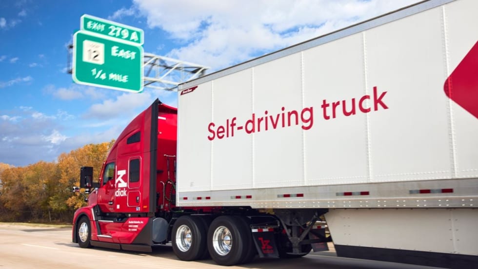 Red Kodiak autonomous truck pulling trailer that says "self-driving truck"