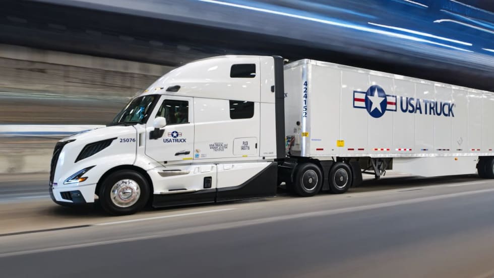 USA Truck branded tractor-trailer on road with blurred background effect