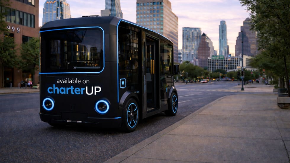 A black and blue HOLON urban autonomous vehicle on a city street.
