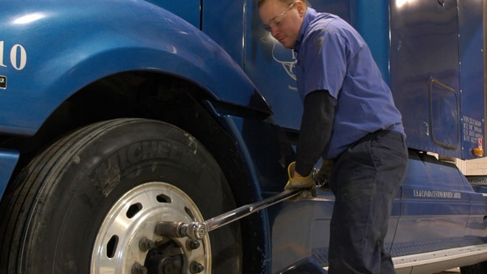 Truck mechanic tightening wheel nuts