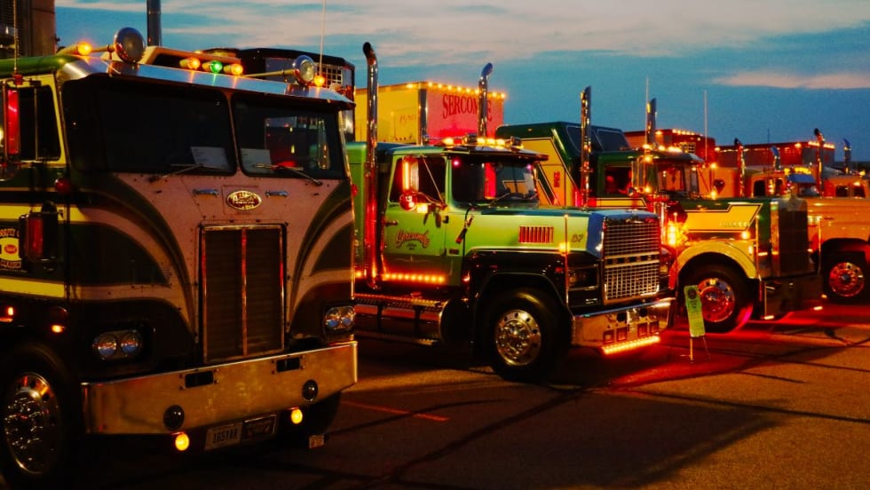 A line of antique trucks at sunset