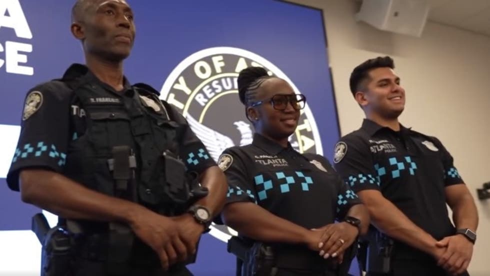 Three Atlanta police officers standing together at official press conference