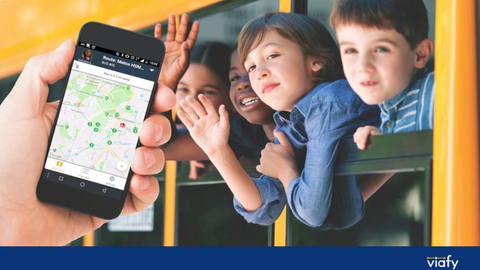 Students waving outside a bus window with an overlay of a hand holding a phone with a transportation tracking app open.