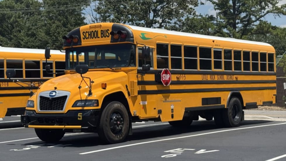 A yellow Little Rock School District school bus in a parking spot.