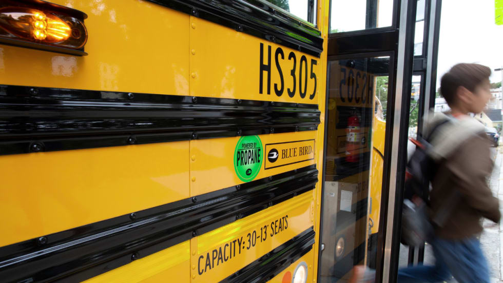 A student disembarks a propane school bus.